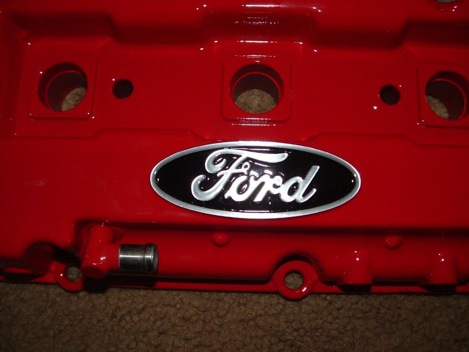Red Ford valve cover with black and silver oval Ford logo