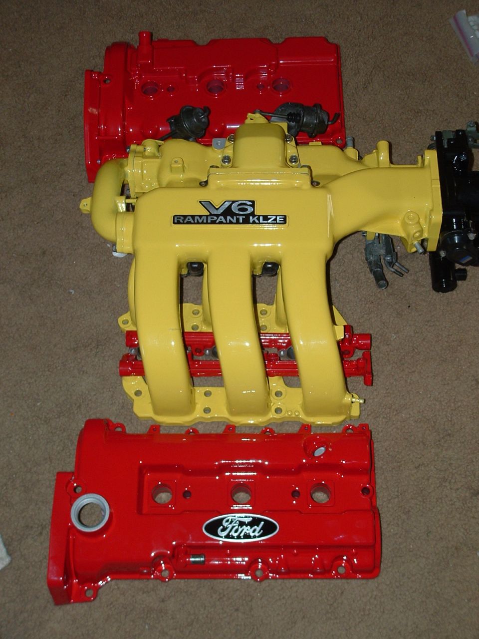 Red Ford valve covers and a yellow V6 intake manifold with 'RAMPANT KLZE' text
