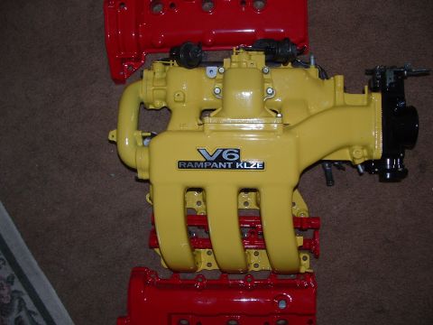 1995 Ford Probe - A yellow V6 intake manifold, labeled 'RAMPANT KLZE', is shown with red engine block components.