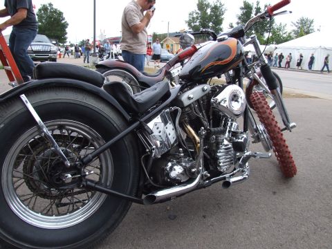 1997 Jeep TJ - A custom motorcycle with flame graphics and chrome details is parked outdoors, with other people and vehicles in the background.