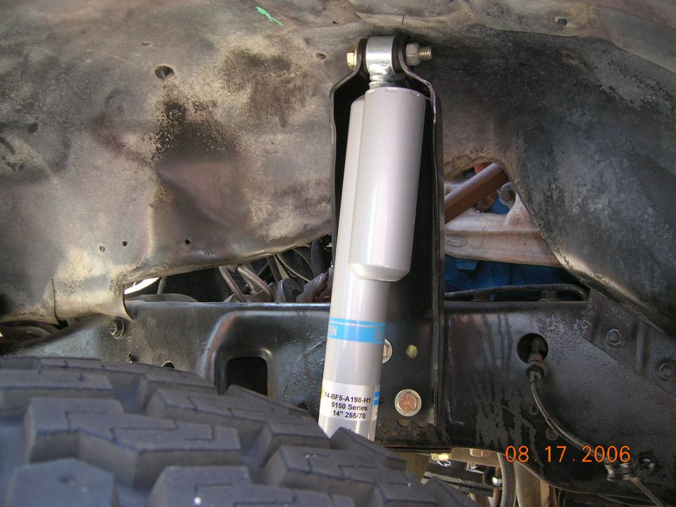 Silver Bilstein 5150 shock absorber mounted under a Bronco's frame near the tire