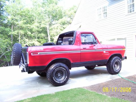 1979 Ford Bronco - This red Ford Bronco features a spare tire mounted on the rear and black trim accents.