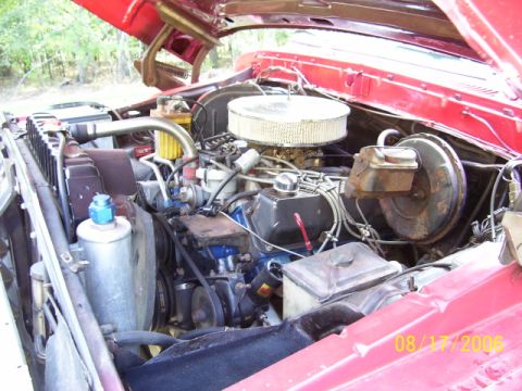 1979 Ford Bronco - Engine compartment view of a red vehicle, showing the V8 engine and associated components.