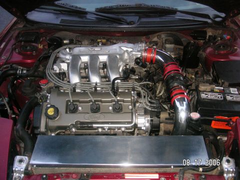 1993 Ford Probe - The engine bay of a car, a V6 intake manifold and a custom intake tube with red accents.