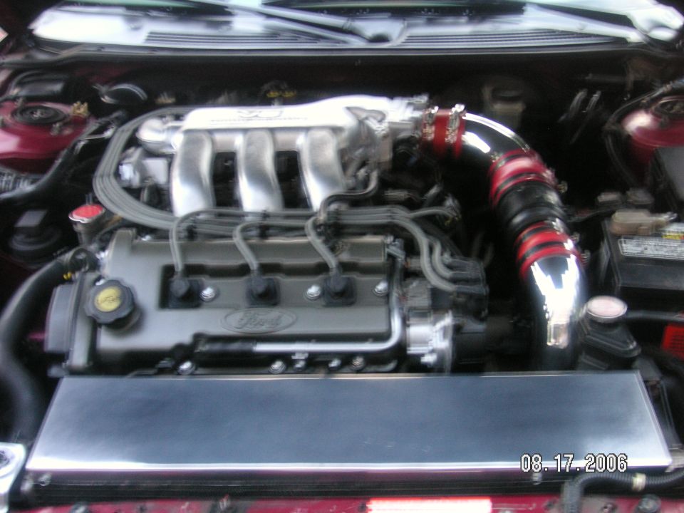 1993 Ford Probe engine bay with aftermarket intake. Ford logo visible on valve cover
