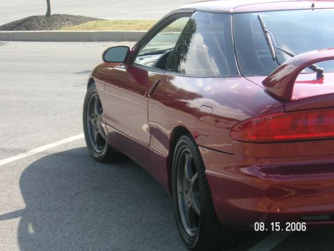 1993 Ford Probe - A maroon 1993 Ford Probe GT is parked in a lot, viewed from the rear quarter panel.