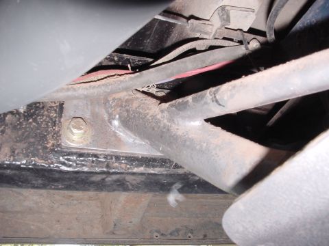 1979 Ford Bronco - Close-up view of the underside of a vehicle, showing structural components and wiring harnesses.