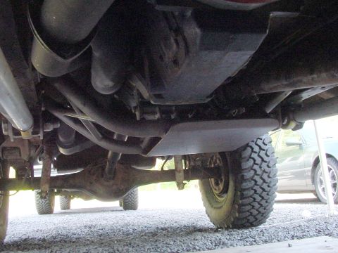 1979 Ford Bronco - The underside of a 4x4 vehicle shows the drivetrain, suspension, and a skid plate.