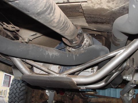 1979 Ford Bronco - Underside view of a 1979 Ford Bronco's drivetrain, including the driveshaft and differential, with a skid plate installed.