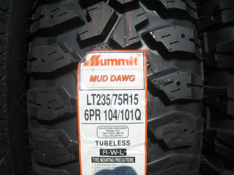 1990 Ford Bronco - Close-up of a Summit Mud Dawg LT235/75R15 tire spec label affixed to the aggressive mud tread.
