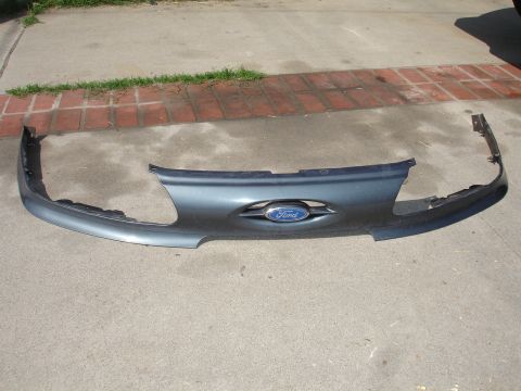 1993 Ford Taurus - Front bumper and grille assembly for a 1993 Ford Taurus, the iconic Ford oval emblem.