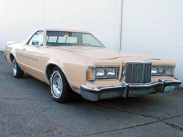 Cream Ford Ranchero pickup, front three-quarter view, chrome grille and whitewall tires, parked by a white wall