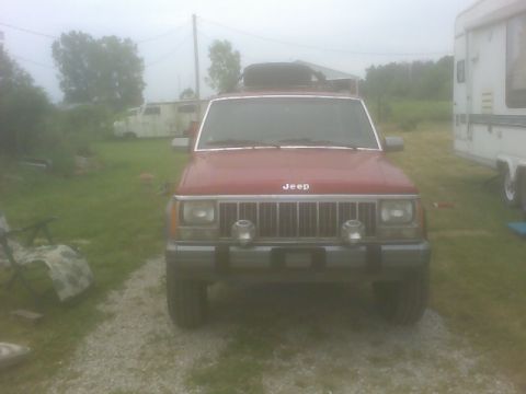 1992 Jeep Cherokee - Front view of a red 1992 Jeep Cherokee parked outdoors with a roof rack.