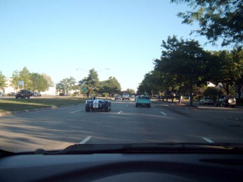 1971 Ford Ranchero - A blue and white striped sports car is seen driving down a tree-lined street.