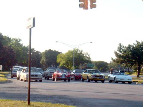 1971 Ford Ranchero - A group of vehicles, some vintage and some modern, are gathered at a traffic light on a sunny day.