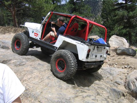 1996 Jeep Cherokee - Modified Jeep Wrangler navigates a rocky off-road trail.