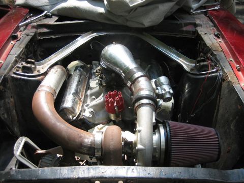 1969 Ford Mustang - Custom turbo build in a 1969 Ford Mustang engine bay, a large turbocharger and extensive piping.