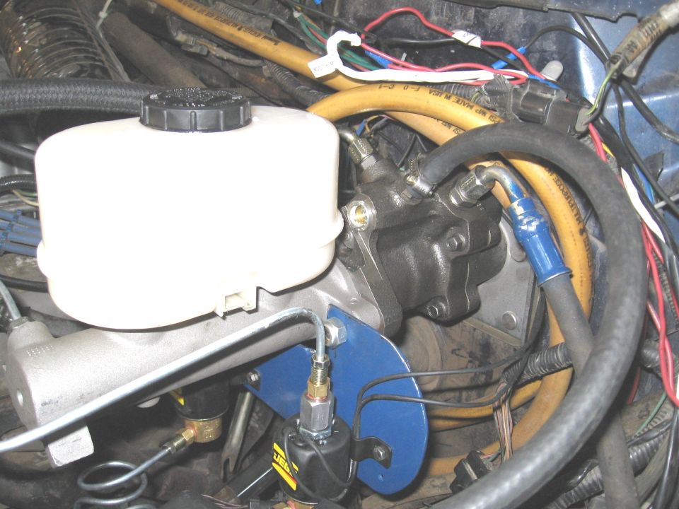 Hydroboost brake booster and master cylinder with yellow power steering hose in engine bay