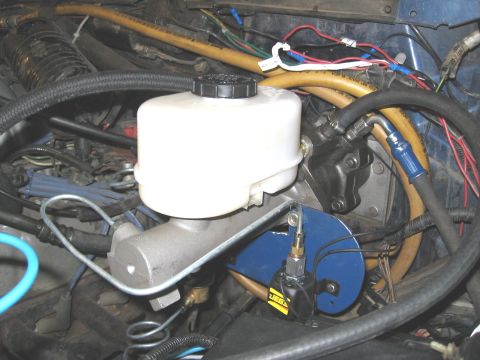 1994 Ford Bronco - Close-up view of a vehicle's master cylinder and brake lines within the engine bay.