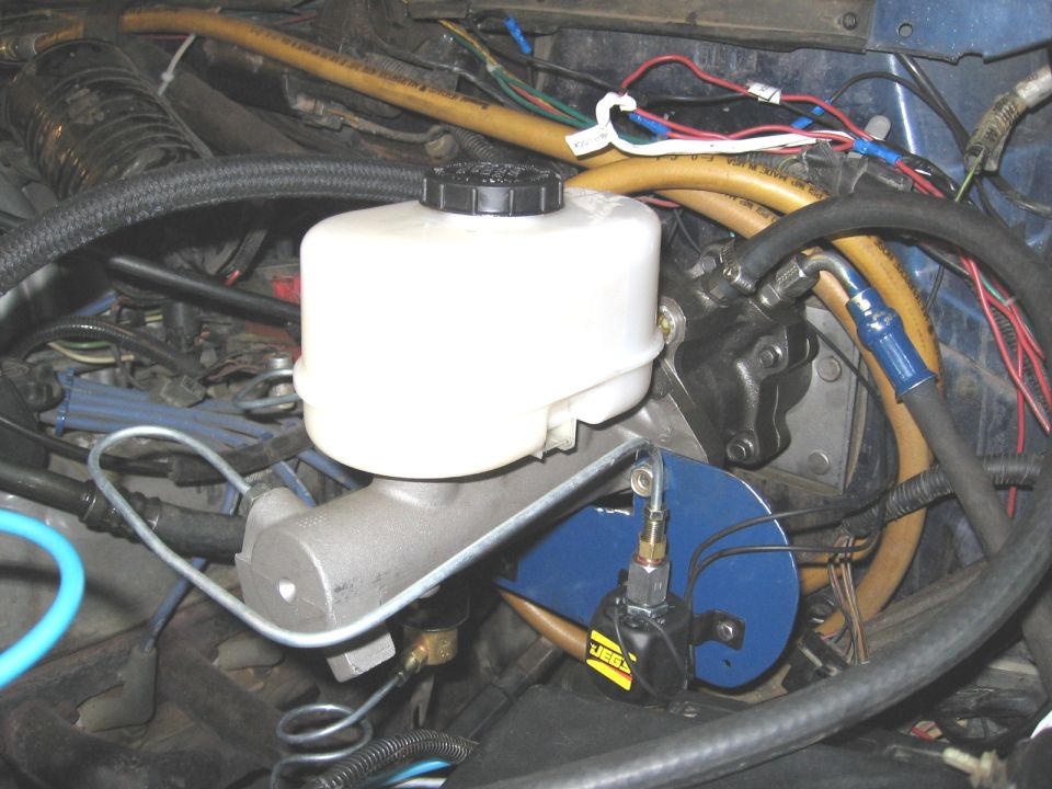 New brake master cylinder and hydraulic hoses installed on firewall in engine bay