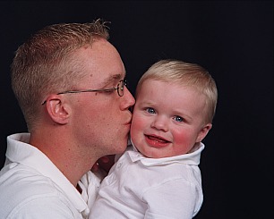 1998 Jeep TJ - A man kisses a smiling baby. The image has a watermark for SUPERMOTORS.NET.