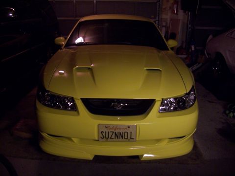 2002 Ford Mustang - Front view of a yellow 2002 Ford Mustang parked indoors. California license plate is visible.