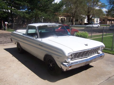 1964 Ford Ranchero - A white 1964 Ford Ranchero pickup truck is parked in a driveway with a red car behind it.