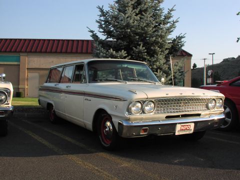 1979 Ford Bronco - A white 1962 Ford Falcon Squire wagon is parked next to another vehicle.