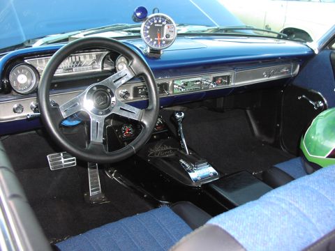 1979 Ford Bronco - The interior of a blue 1964 Ford Galaxie features an aftermarket steering wheel, tachometer, and racing shifter.