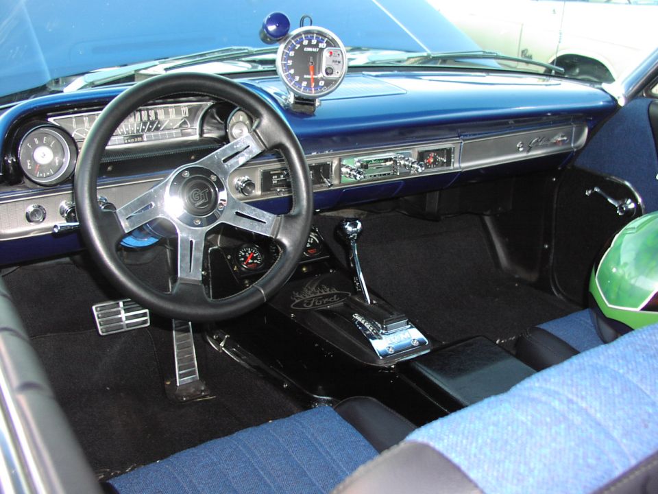 Interior of a blue 1964 Ford Galaxie with aftermarket steering wheel and tachometer