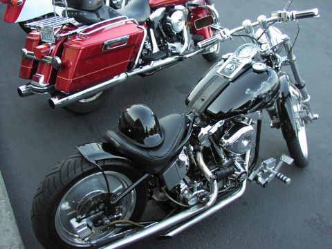 1979 Ford Bronco - Two motorcycles, one black and one red, are parked side-by-side on asphalt.
