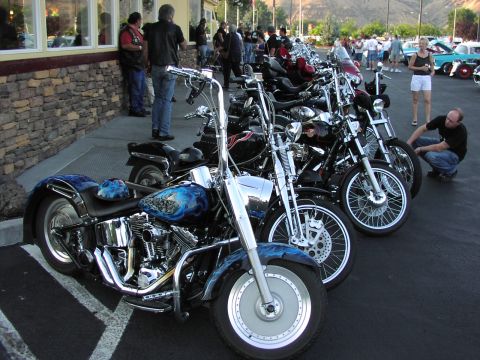 1979 Ford Bronco - Several custom motorcycles with intricate blue flame paint designs are parked in a row outside a building.