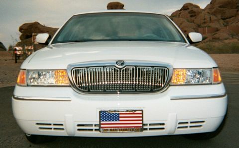 2001 Mercury Grand Marquis - A white Mercury Grand Marquis is shown from the front, parked outdoors with rocky hills in the background.