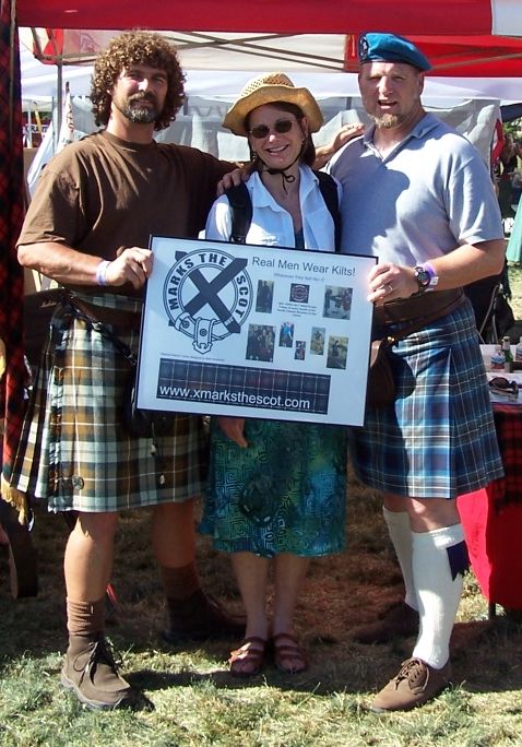 1990 Ford Bronco - People pose with a sign promoting kilts and a website for "Marks the Scot" at an outdoor event.