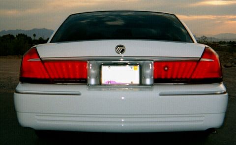 2001 Mercury Grand Marquis - The rear of a white 2001 Mercury Grand Marquis is shown, its distinctive taillight design and chrome accents.