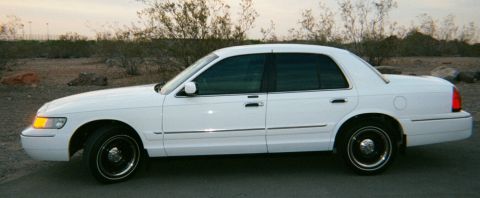 2001 Mercury Grand Marquis - White 2001 Mercury Grand Marquis sedan parked outdoors with a desert landscape in the background.
