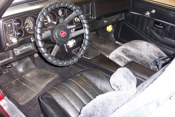 Interior of a 1979 Chevrolet Camaro showing the dashboard, steering wheel, seats, and floor mats