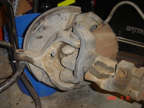 1993 Ford Bronco - A close-up view of a vehicle's axle and brake system, showing the rotor and caliper.