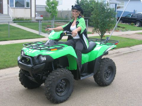 1995 Ford Bronco - Woman on a green ATV in front of a house.