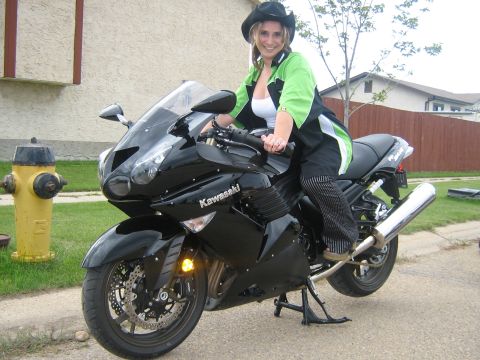 1995 Ford Bronco - Woman on a black Kawasaki motorcycle parked on a street with a fire hydrant nearby.