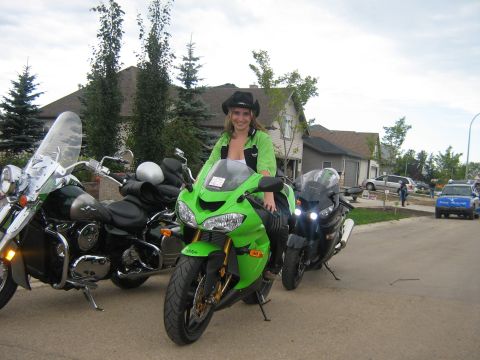 1995 Ford Bronco - A woman poses on a bright green motorcycle, flanked by two other bikes on a suburban street.