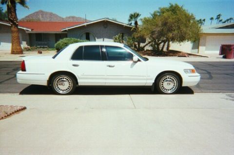 2001 Mercury Grand Marquis - Roush Performance spoiler and LS wheel covers, including a big chunk of my driveway.