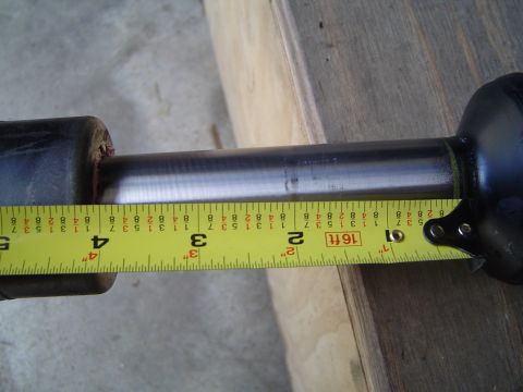 1989 Ford Bronco - A shock absorber is measured with a yellow tape measure, showing approximately 4 inches.