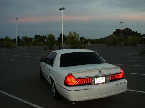 2001 Mercury Grand Marquis - A white 2001 Mercury Grand Marquis is parked in an empty lot as the sun sets.
