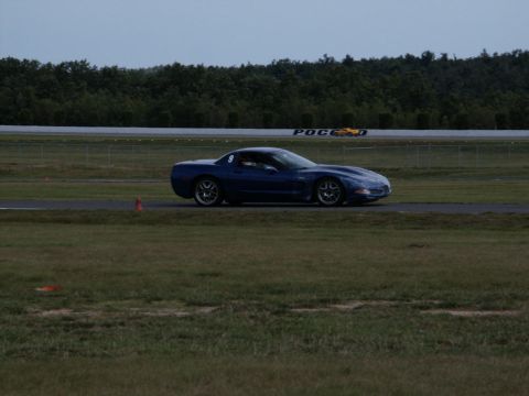 2001 Mercury Grand Marquis - A blue sports car is seen on a race track with trees in the background.
