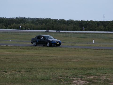 2001 Mercury Grand Marquis - A black sedan navigates a race track under an overcast sky.