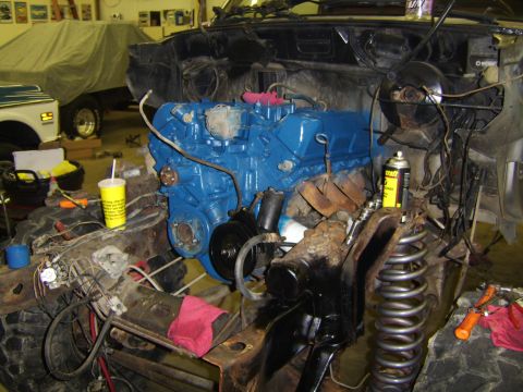 1986 Ford Ranger - The engine bay of a vehicle undergoing work, a freshly painted blue engine and various mechanical components.