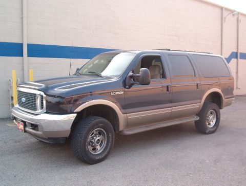 2000 Ford Excursion - Ford Excursion SUV parked in front of a building with blue and white stripes.