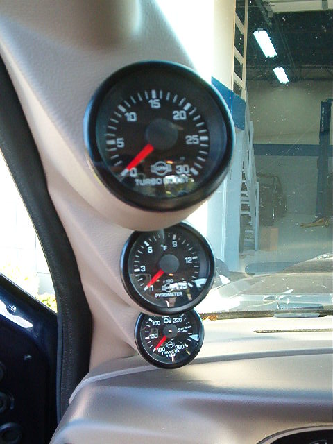 2000 Ford Excursion - Interior shot showing a cluster of three gauges, including turbo boost and pyrometer readings.