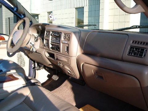 2000 Ford Excursion - The interior of a 2000 Ford Excursion shows a tan dashboard with a radio and air vents.
